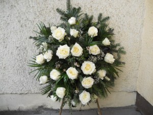 Wieniec pogrzebowy z białych róż stojący